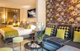 A Junior Suite with a floral wall and a corner sofa, Hotel Hermitage, Breuil-Cervinia