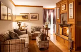 The living room of a Master Suite with a fireplace at Hotel Hermitage, Breuil-Cervinia