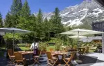 Terrace tables under parasols in the summer garden at Hotel Hermitage, Breuil-Cervinia