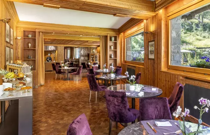 The breakfast room with purple chairs at Hotel Hermitage, Breuil-Cervinia