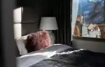 A bedroom with a fur cushion and a window onto the balcony at No. 14 Verbier