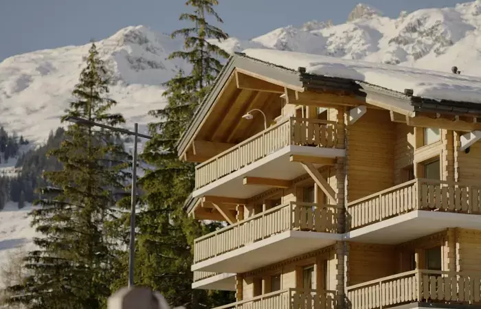 The chalet facade with wooden balconies under snow at No. 14 Verbier