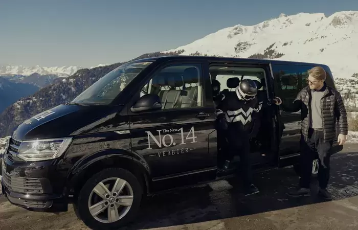 A skier and a man beside the No. 14 chalet van in Verbier